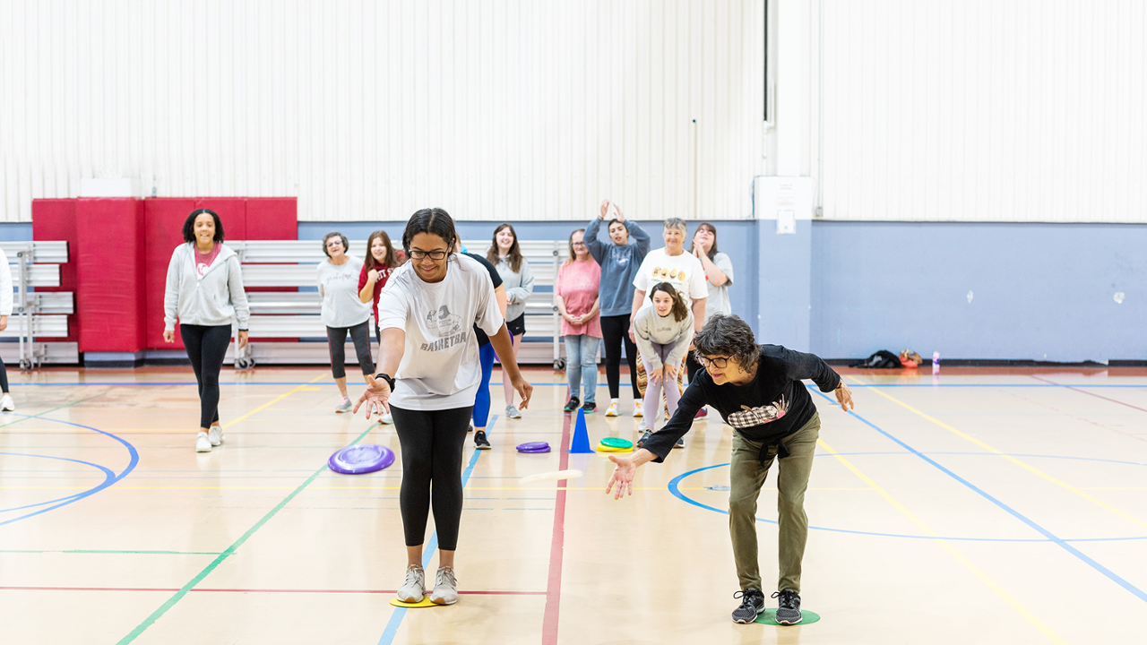 therapeutic recreation student playing frisbee with community member