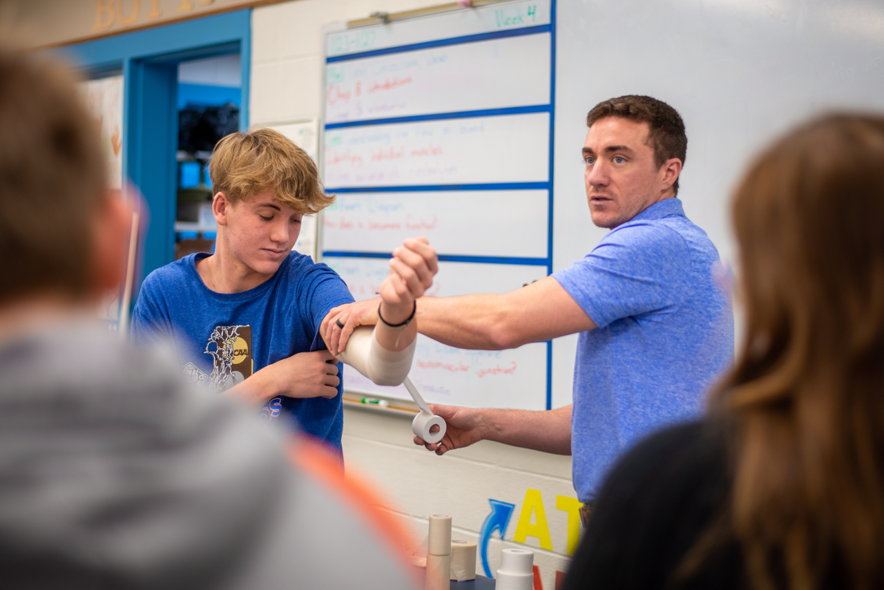 student with athletic trainer