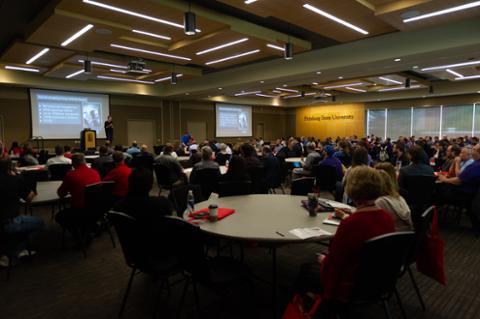 Brian McClendon on stage in front of a full audience as he talks about his time at Google.