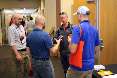 Four conference goers standing in a circle and chatting.