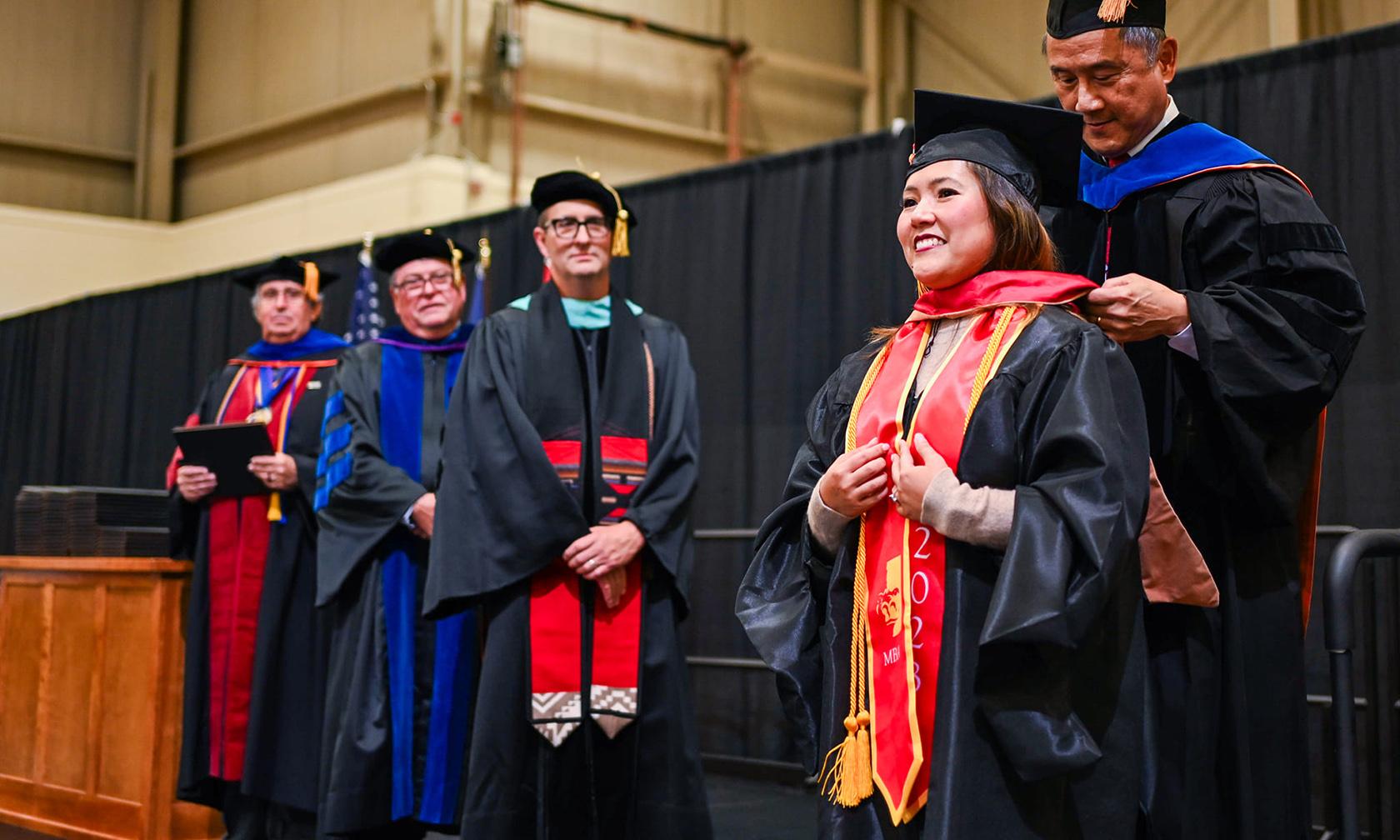 Commencement graduates getting diplomas