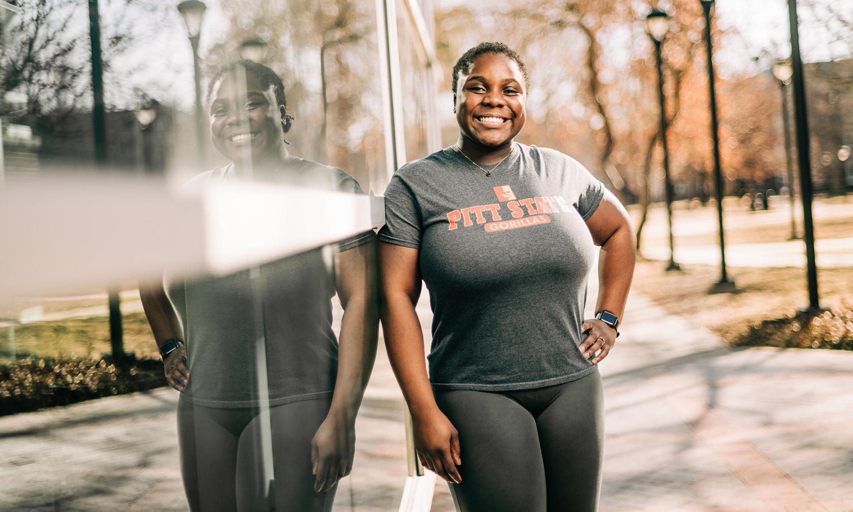 Coleen, president of the Black Student Association, leaning against a wall on campus