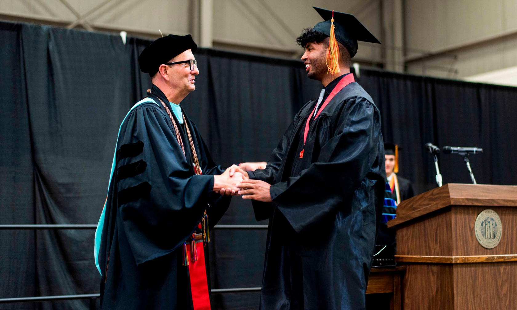 President Dan Shipp shaking hands with graduate Kyle Carr