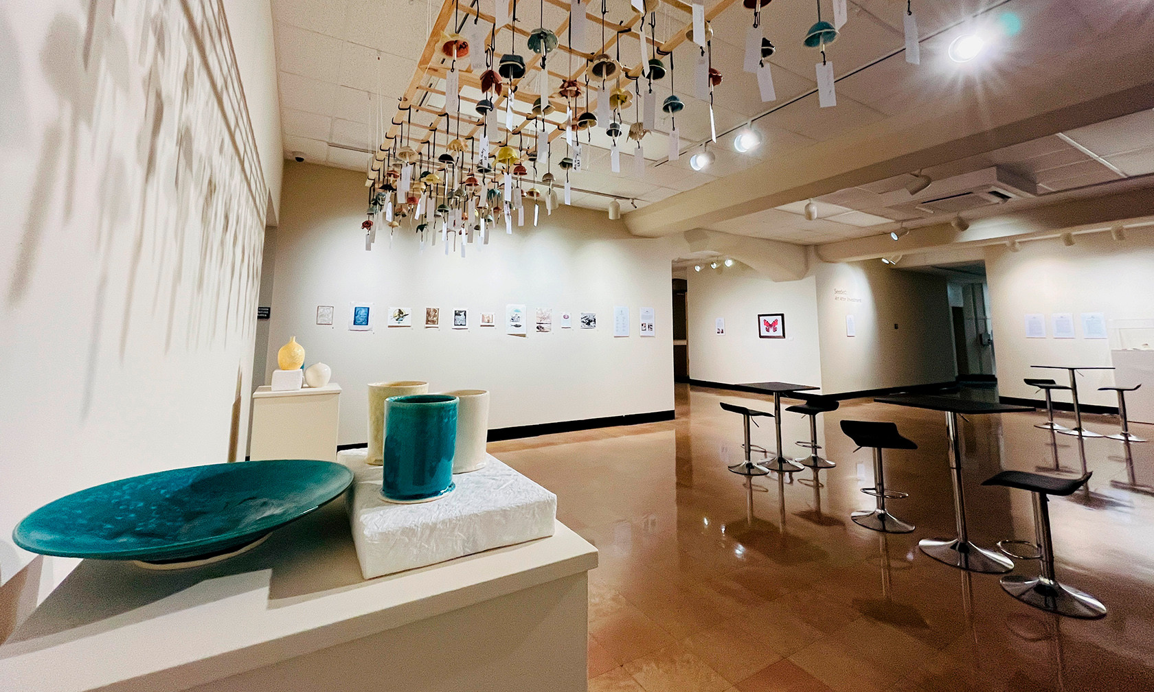 exhibit in art gallery showing ceramics and prints