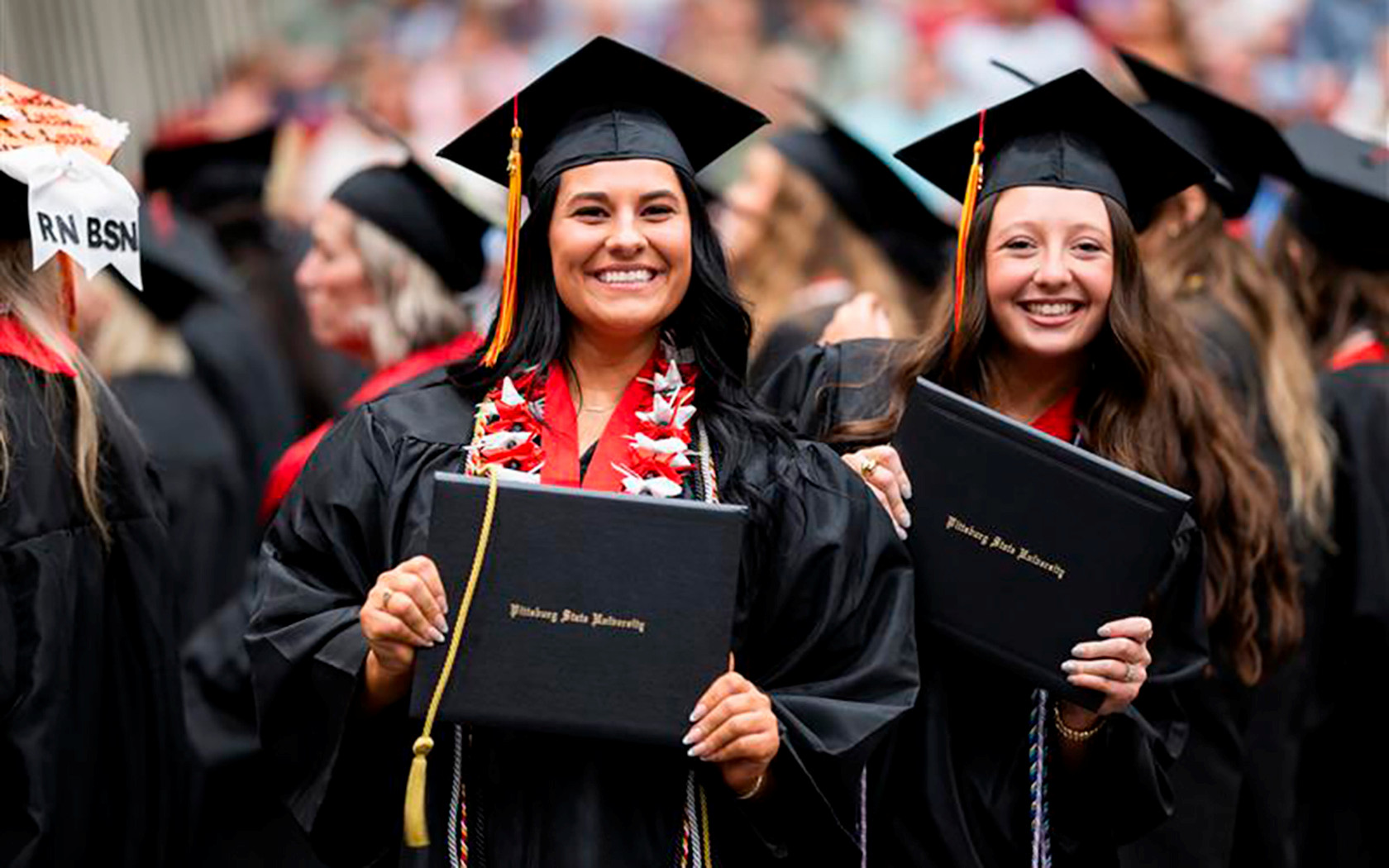 Graduate proudly holding their diploma