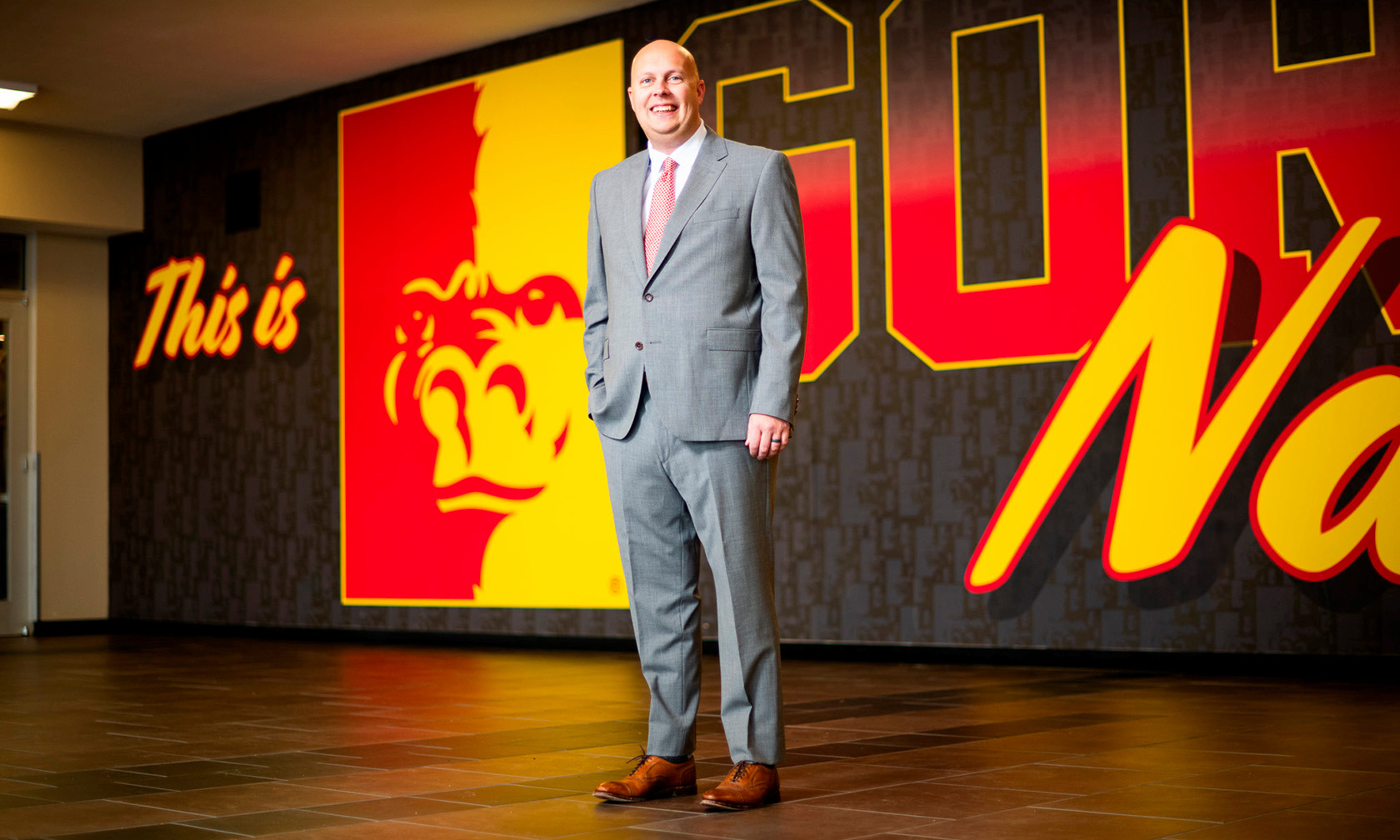 Anthony Crespino standing in front of Pitt State splitface logo