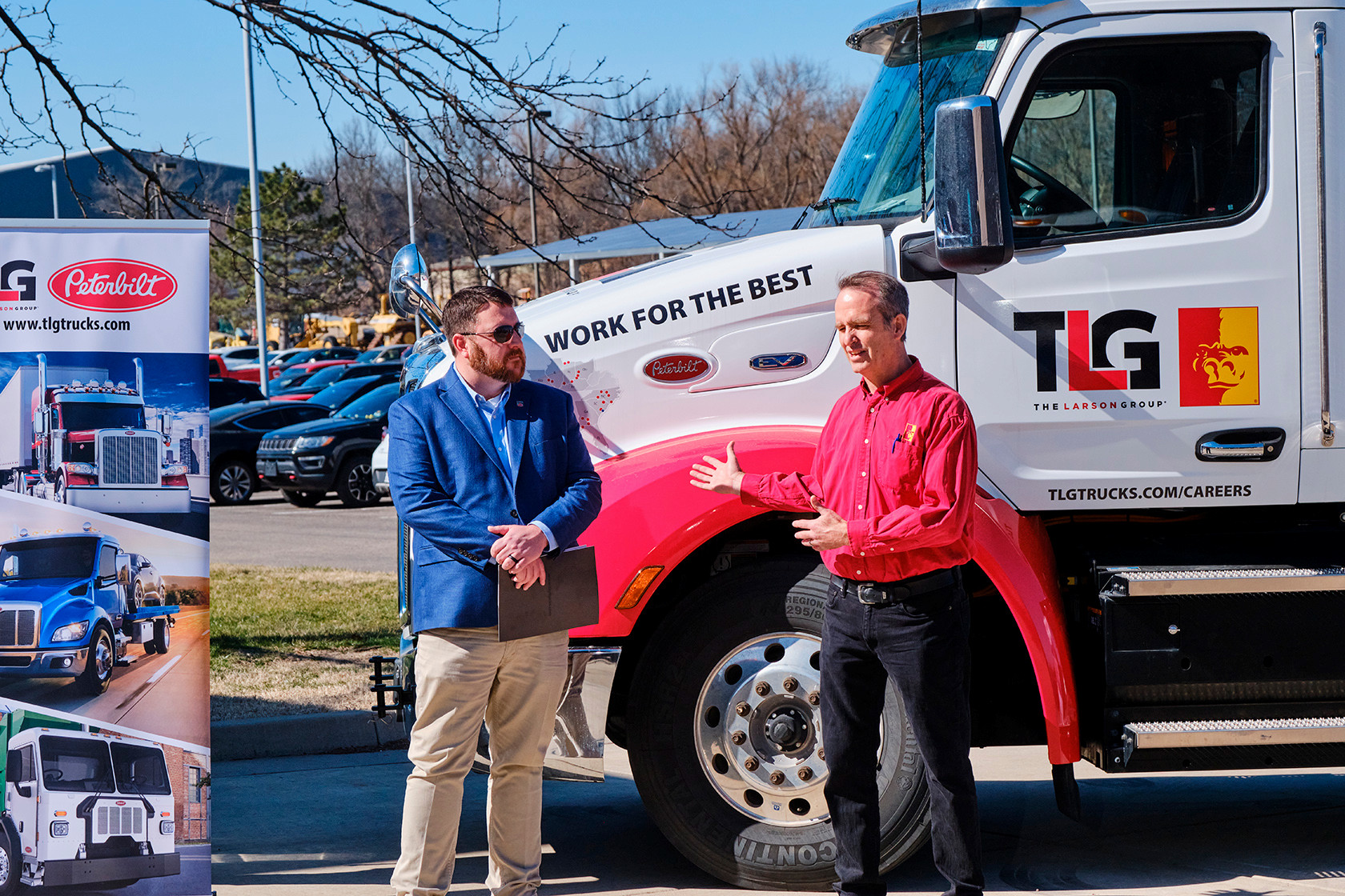 Two men stand infront of the new Peterbilt Donated Semi truck 