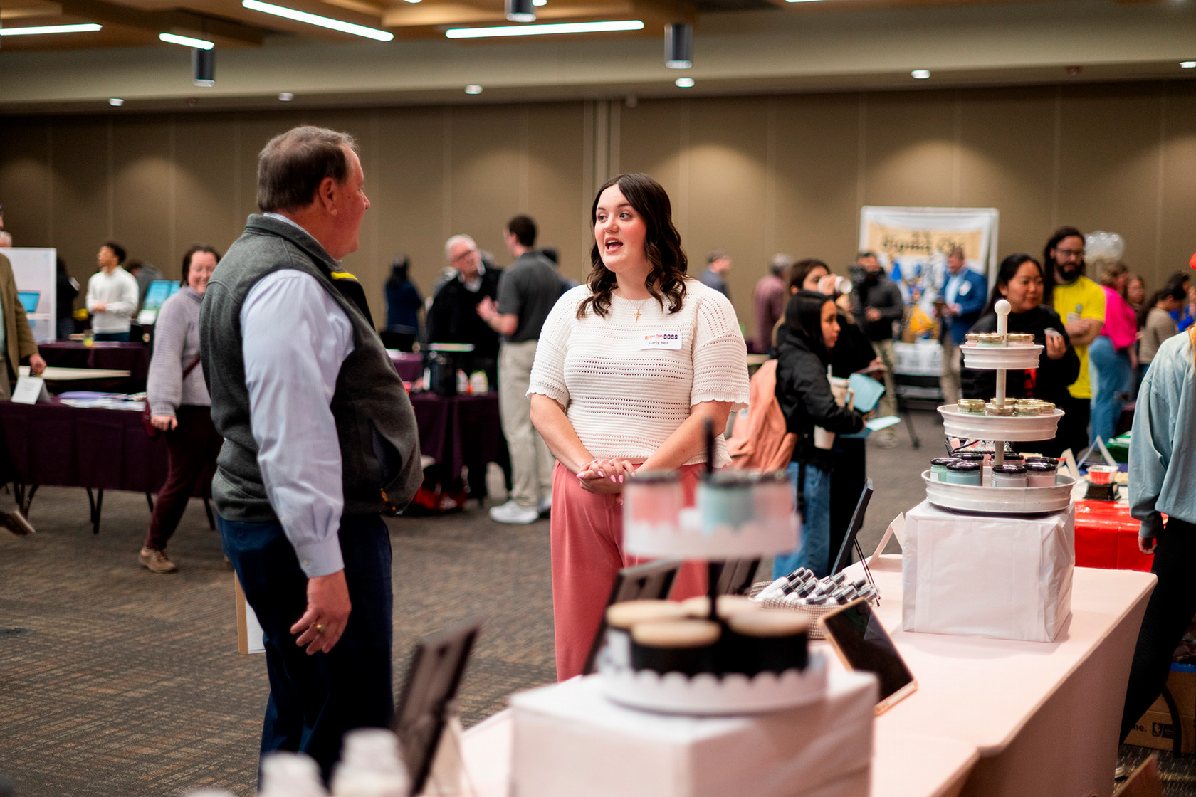A girl talks to a gentlemen as she presents her idea