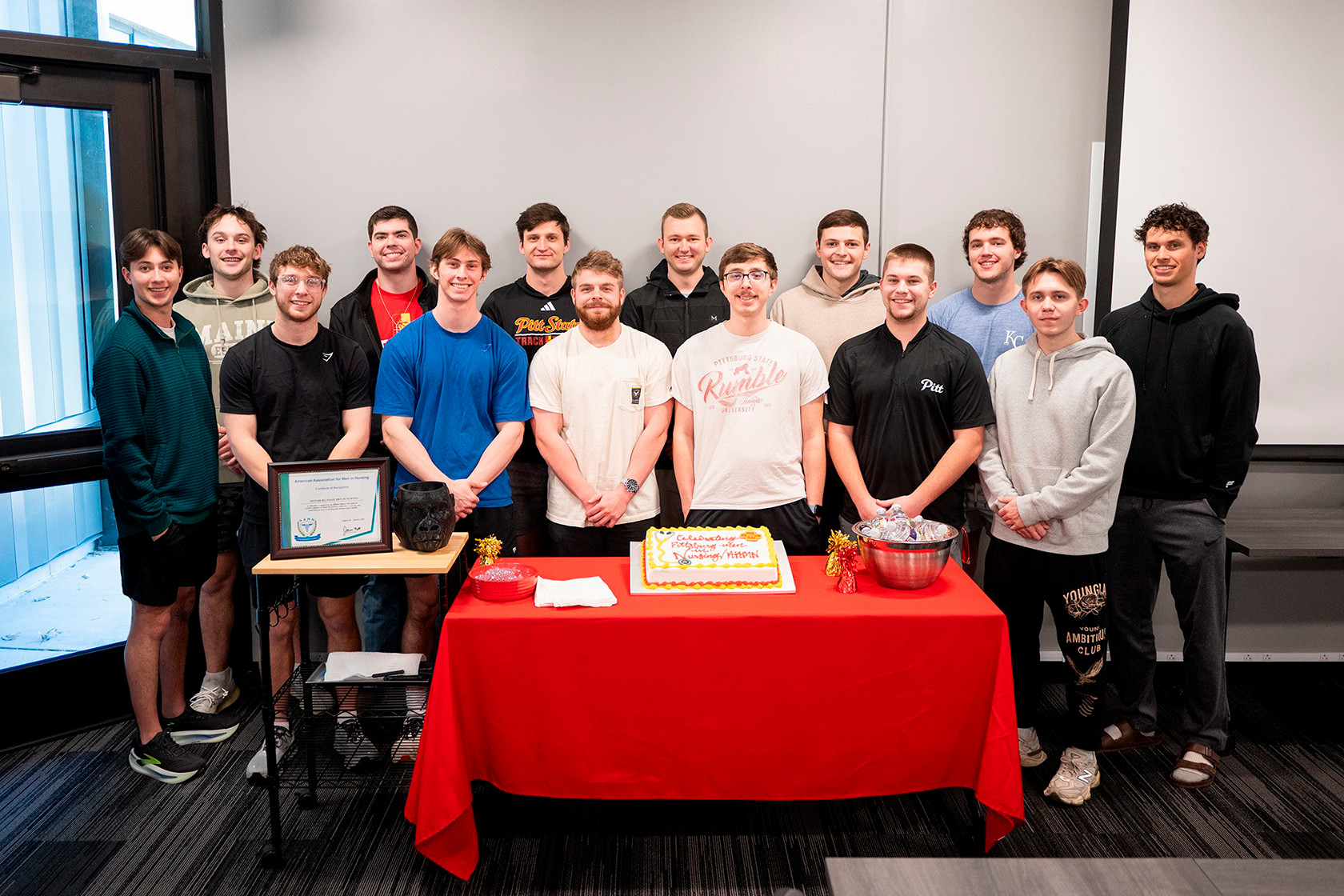 Men nursing students pose behind a table for a photo 