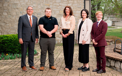 Staff award recipients pose outside the presidential home with President Newsom and Charlie