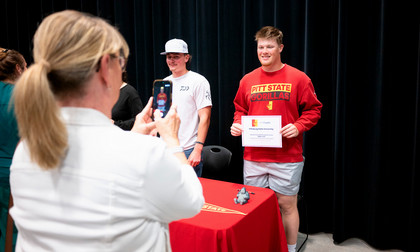 student smiling while mom takes photo