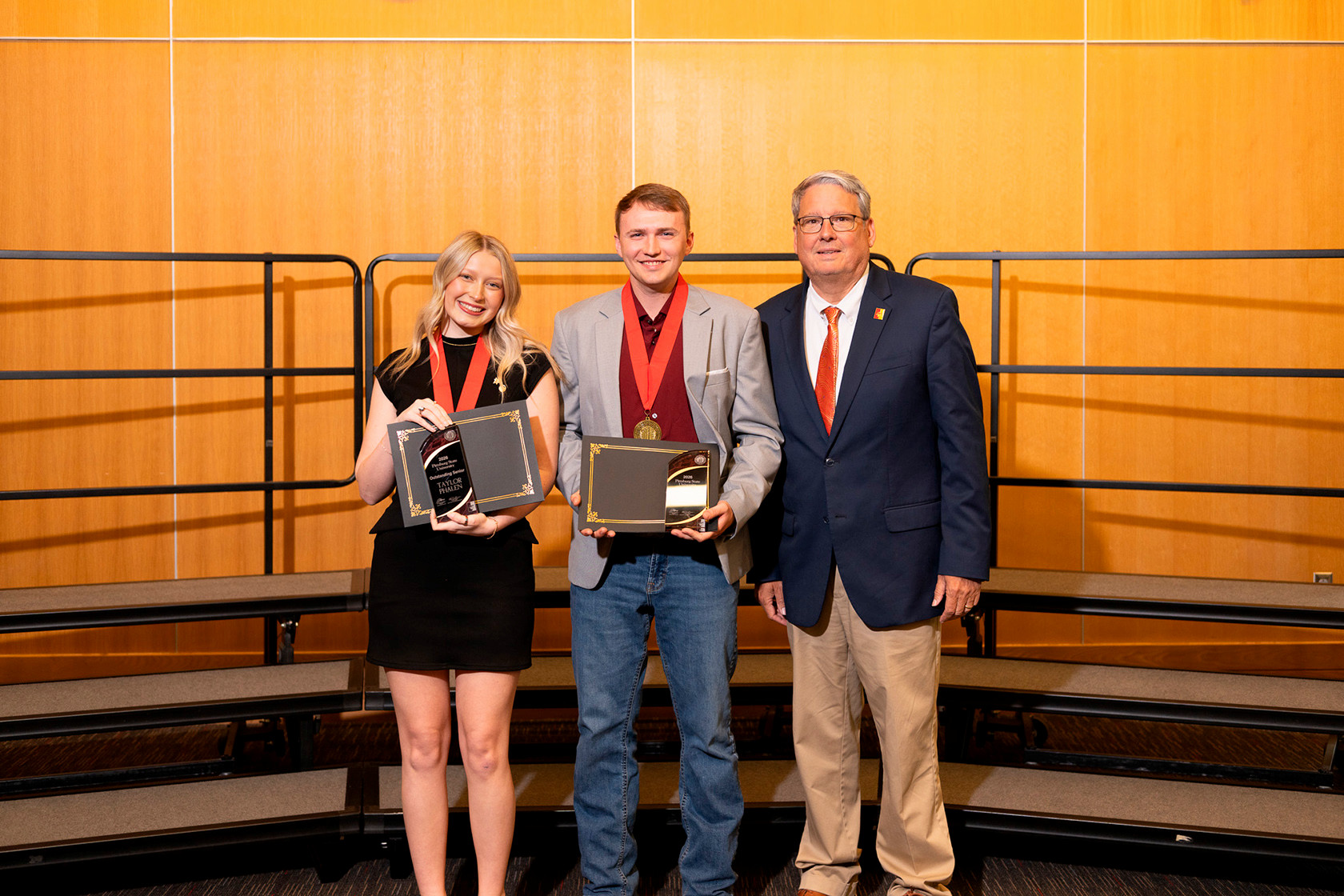 From left to right: Taylor, Austin, and Dr. Newsom pose for a photo holding up their awards
