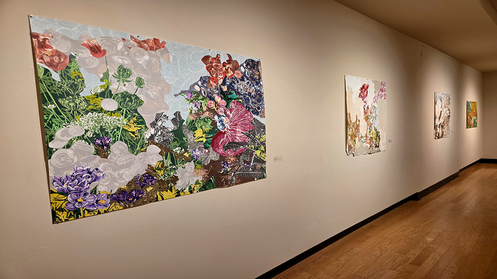 A wide shot of paintings hanging in a gallery