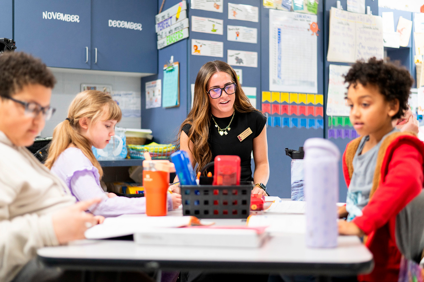 A women works with children in a classroom setting 