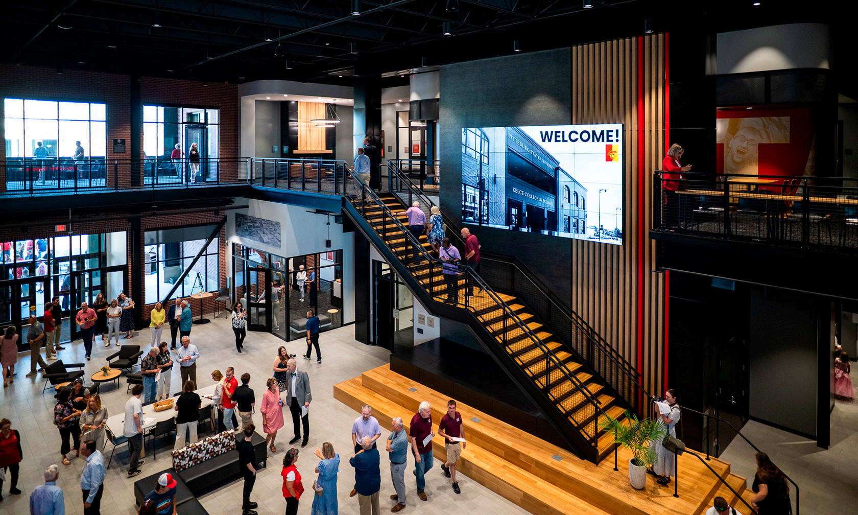 large atrium in new building with staircase and people gathered