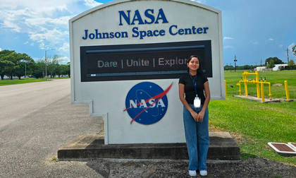 Monika standing by a sign that says NASA