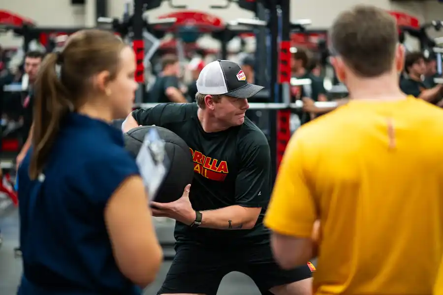 an athlete preparing to throw a medicine ball in a weights facility