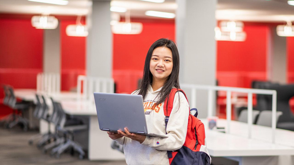 student in library with laptop