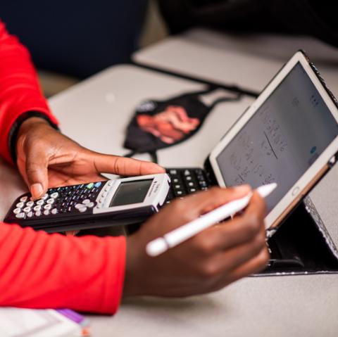 College student with calculator completing math major coursework