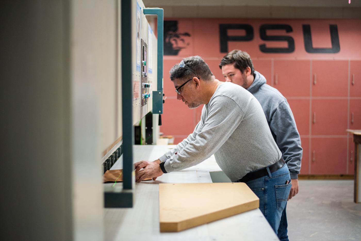 Wood student and teacher with machine